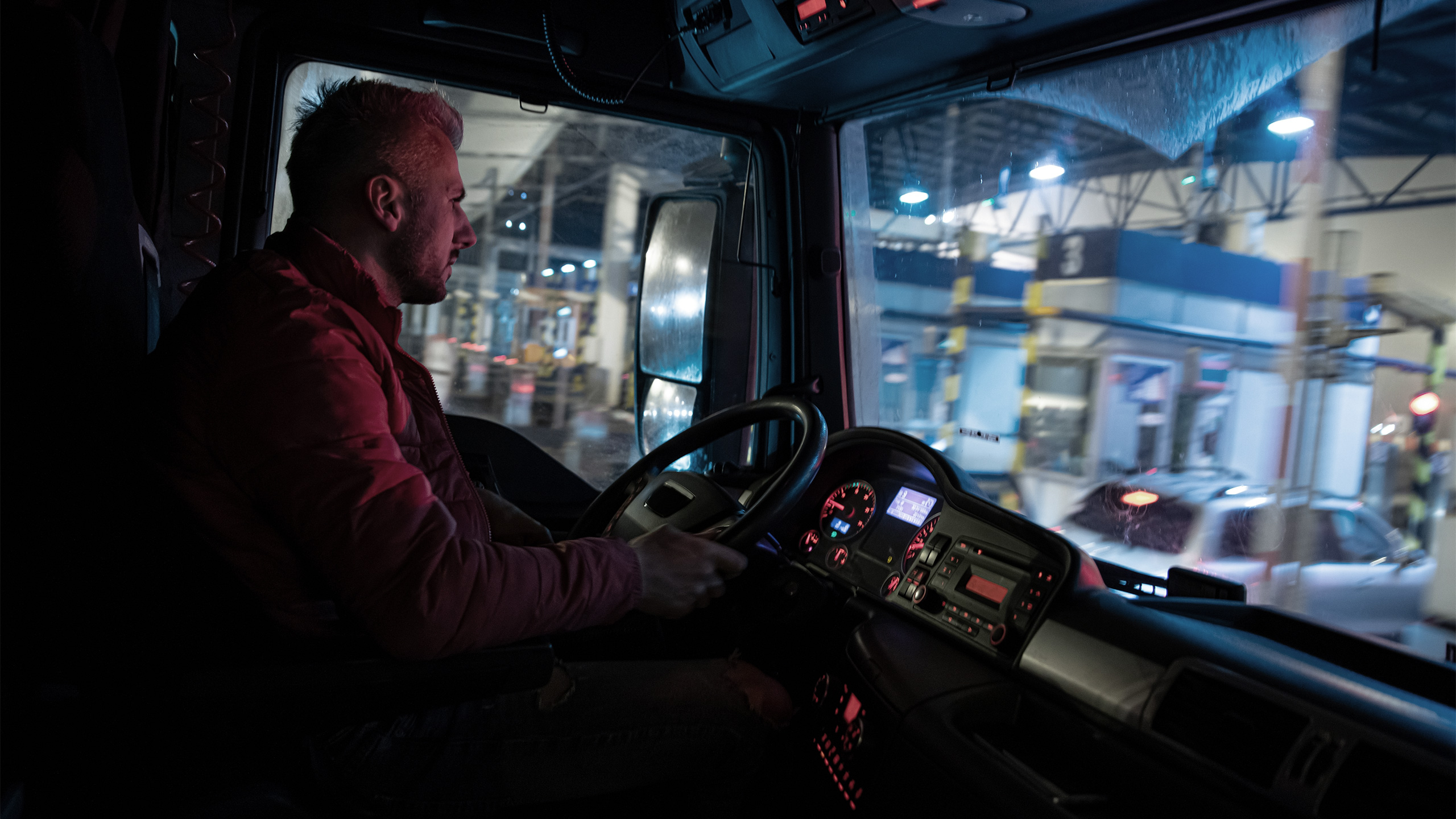 [Translate to Französisch:] LKW Fahrer fährt bei Nacht