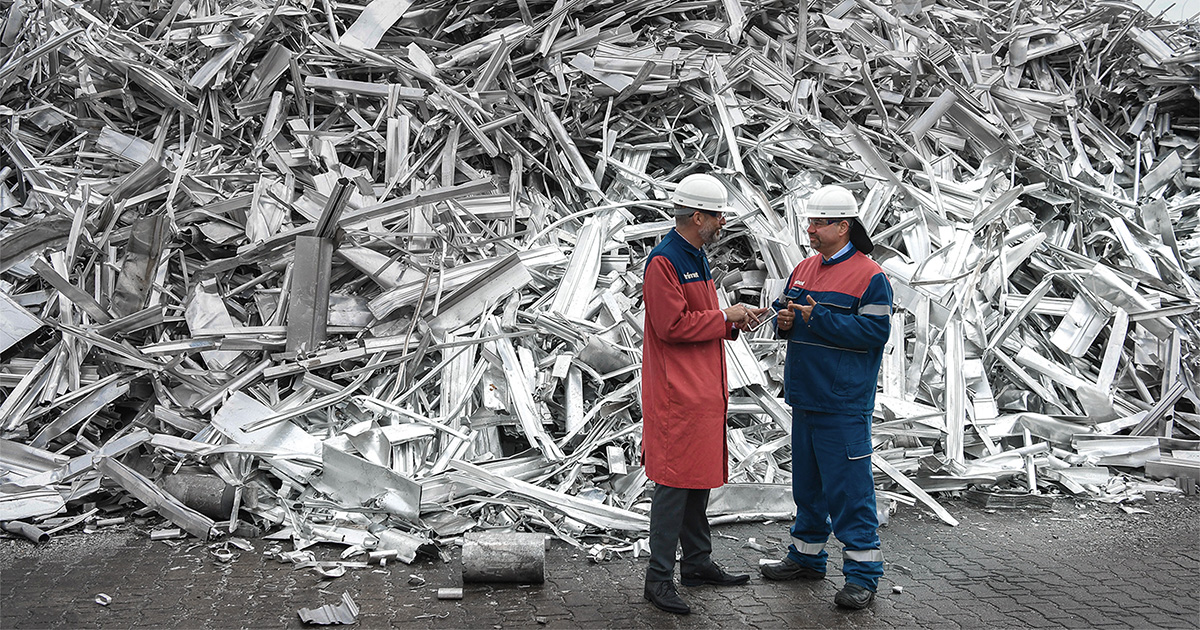 Aluminiumschrottberg mit zwei TRIMET Mitarbeitern